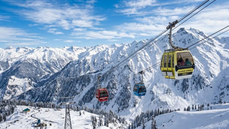 Red Gulmarg cable car moving over snow covered mountains in Kashmir