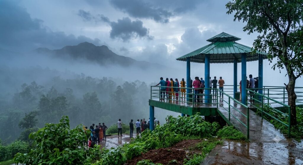 Tourists standing on a green covered viewpoint gazebo overlooking misty mountains and thick fog during a heavy monsoon rain in Bisle Ghat, Sakleshpur.