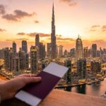 Dubai skyline with Burj Khalifa at sunset and blurred passport in foreground representing Dubai tourist visa 2026 fast approval.